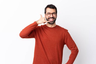 Beyaz arka planda sakallı, beyaz tenli beyaz bir adam telefon jesti yapıyor. Bana geri dönüş işareti ver.