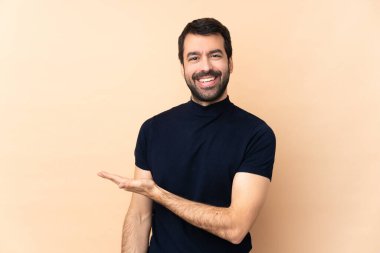 Kafkasyalı yakışıklı adam soyutlanmış bir arka planda gülümserken bir fikir sunuyor.