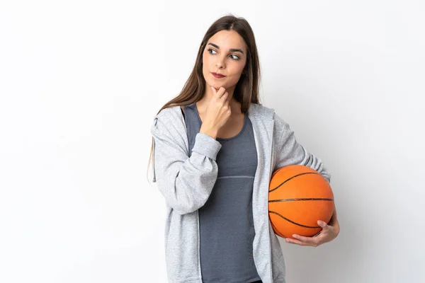 Молодая Женщина Играет Баскетбол Изолированы Белом Фоне Глядя Сторону Улыбаясь — стоковое фото