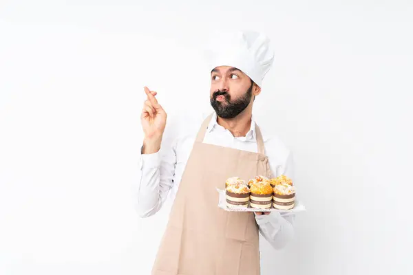 Jongeman Houdt Muffin Cake Geïsoleerde Witte Achtergrond Met Vingers Kruisen — Stockfoto