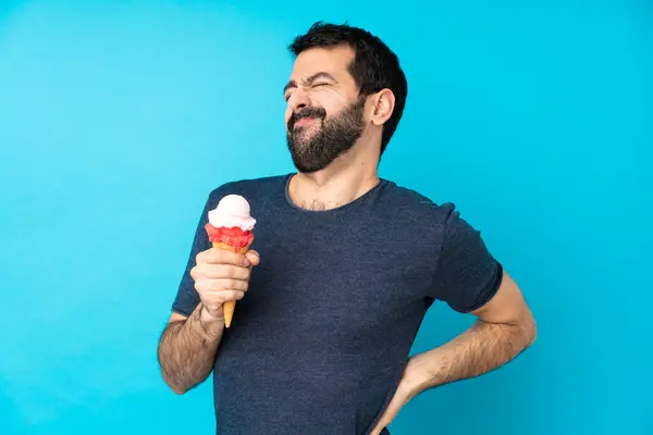 Young Man Cornet Ice Cream Isolated Blue Background Suffering Backache — Stock Photo, Image