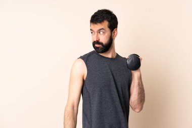 Beyaz sakallı sporcu izole edilmiş arka planda ağırlık kaldırıyor. Portre