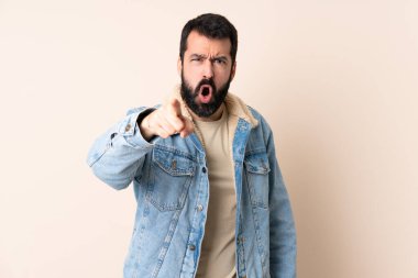 İzole edilmiş arka planda sakallı beyaz bir adam hayal kırıklığına uğramış ve ön tarafı işaret ediyor.