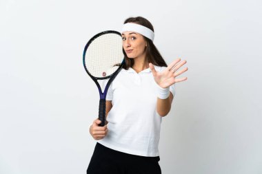 İzole edilmiş beyaz arka planda genç bayan tenisçi parmaklarıyla beşi sayıyor
