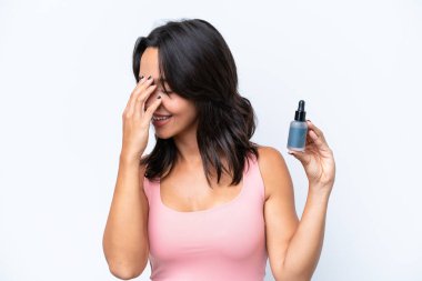 Beyaz arka planda izole edilmiş serumu tutan genç İspanyol kadın gülüyor.