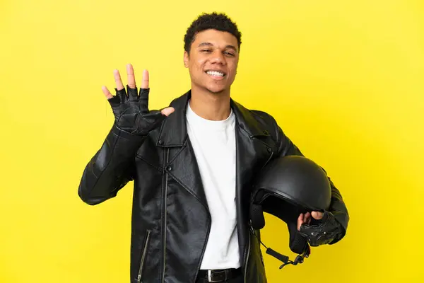年轻的非洲裔美国人 头戴摩托车头盔 背景是黄色的 有五个手指头 — 图库照片