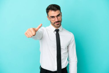 Beyaz iş adamı mavi arka planda izole edildi. Başparmakları havada çünkü iyi bir şey oldu.