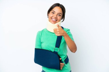 Boyunluk takan genç İspanyol kadın ve askısı beyaz arka planda izole edilmiş, başparmakları havada çünkü iyi bir şey oldu.