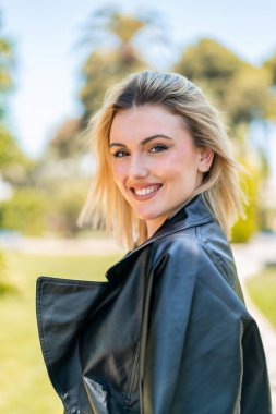 Açık havada güzel sarışın bir kadın Neşeli bir ifadeyle