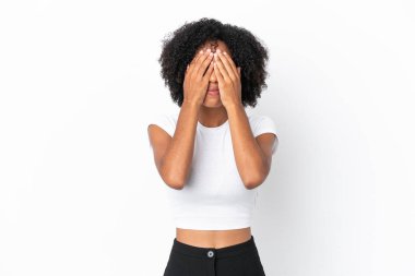 Beyaz arka planda izole edilmiş genç Afrikalı Amerikalı kadın gözleri elleriyle kaplıyor.