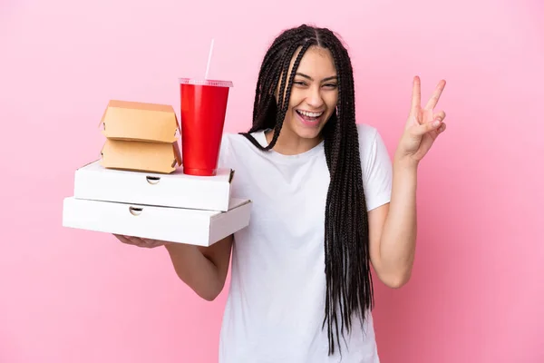 Chica Adolescente Con Trenzas Sosteniendo Pizzas Hamburguesas Sobre Fondo Rosa — Foto de Stock
