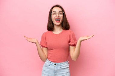 Genç Ukraynalı kadın pembe arka planda izole edilmiş, şok olmuş yüz ifadesi var.