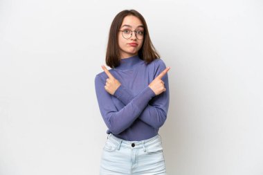 Beyaz arka planda izole edilmiş genç Ukraynalı kadın yan kesimlerin şüphelerine işaret ediyor.