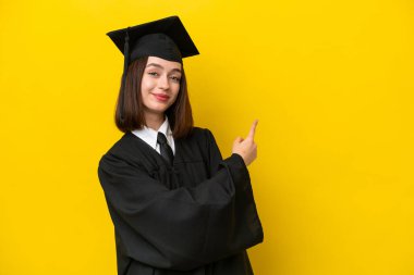 Genç üniversite mezunu Ukraynalı kadın sarı arka planda izole edilmiş.