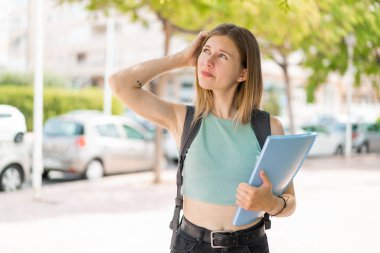 Açık havada genç sarışın bir bayan şüpheleri var ve kafası karışık.