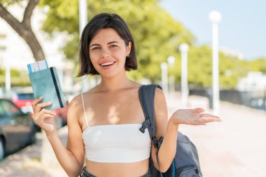 Genç, güzel bir Bulgar kadın elinde şok olmuş bir yüz ifadesiyle dışarıda bir pasaport tutuyor.