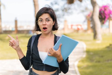 Genç Bulgar öğrenci kadın açık havada şaşkın ve işaret ediyor
