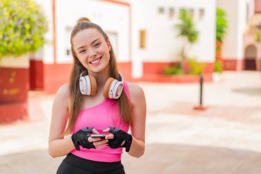 Dışarıdaki güzel kız cep telefonuyla mesaj yolluyor.