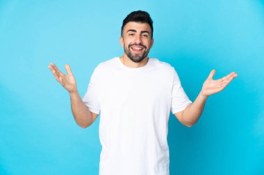 İzole edilmiş mavi arka planı olan beyaz bir adam çok fazla gülümsüyor.