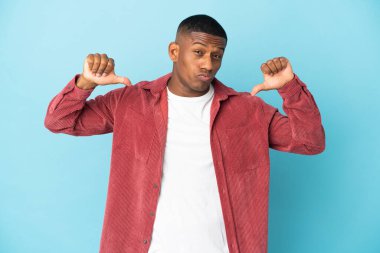 Mavi arka planda soyutlanmış genç Latin adam gururlu ve kendini beğenmiş.