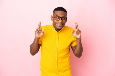 Pembe arka planda izole edilmiş genç bir latin adam.