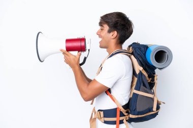 Genç dağcı kadın, izole edilmiş beyaz arka planı olan büyük bir sırt çantasıyla megafonla bağırıyor.