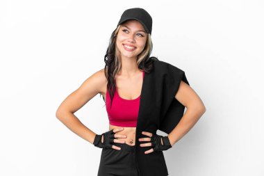 Beyaz arka planda izole edilmiş, kalçasında kollarıyla poz veren ve gülümseyen şapkalı Rus kız.