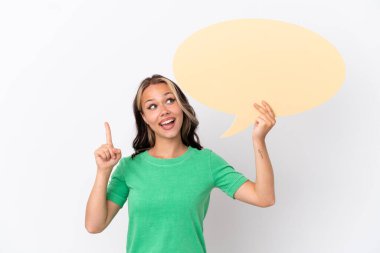 Genç Rus kız mavi arka planda izole edilmiş boş bir konuşma balonu tutuyor ve düşünüyor.