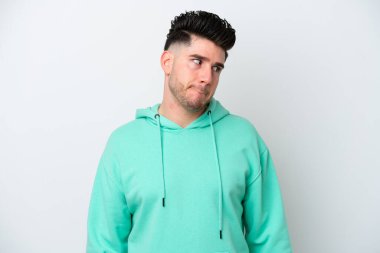 Beyaz arka planda izole edilmiş genç beyaz adam yukarı bakarken şüpheleri var.