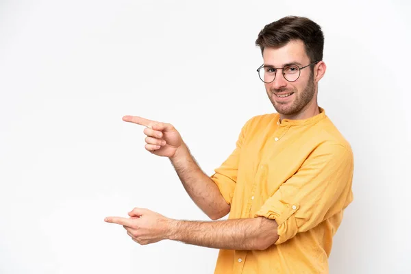 白い背景の指を横に向けて製品を提示する若い白人男性 — ストック写真