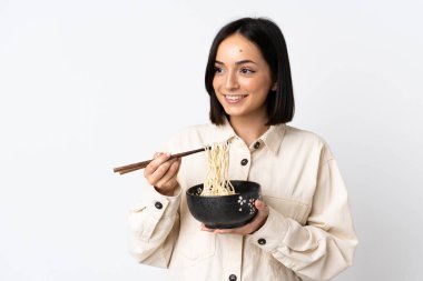 Beyaz arka planda izole edilmiş beyaz bir kadın elinde çubuklu bir kase erişteyle yukarı bakıyor.