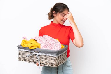 Young caucasian woman holding a clothes basket isolated on white background laughing