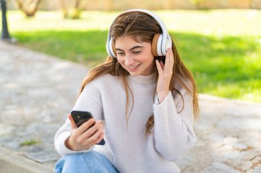 Cep telefonu kullanan güzel beyaz bir kadın.