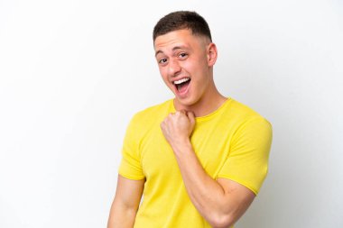 Genç Brezilyalı izole edilmiş beyaz arka planda zaferi kutluyor.