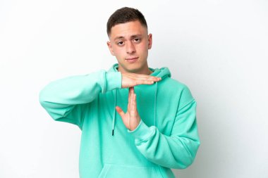 Genç Brezilyalı bir adam beyaz arka planda izole edilmiş bir şekilde jest yapıyor.