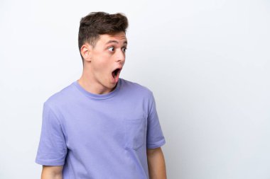 Beyaz arka planda izole edilmiş yakışıklı Brezilyalı bir adam. Yan tarafa bakarken sürpriz jest yapıyor.