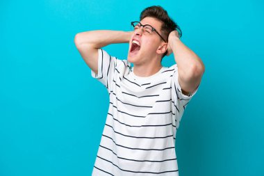 Genç ve yakışıklı Brezilyalı bir adam mavi arka planda izole edilmiş.