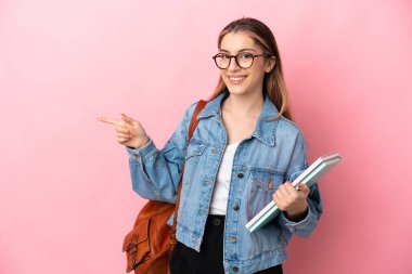 Pembe arka planda izole edilmiş beyaz, genç bir bayan parmak kenarı gösteriyor.