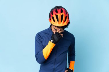 Venezuelalı bisikletçi, mavi arka planda izole edilmiş gülüyor.