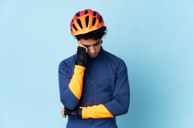 Venezuelalı bisikletçi mavi arka planda baş ağrısı ile izole edilmiş.