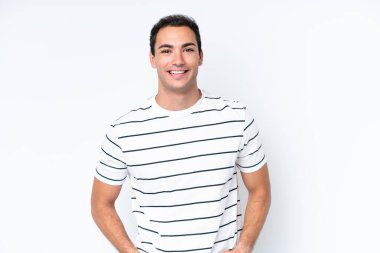 Beyaz arka planda izole edilmiş genç beyaz adam mutlu ve gülümsüyor.