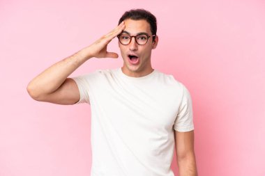 Pembe arka planda izole edilmiş genç beyaz adam bir şey fark etti ve çözüme niyetlendi.