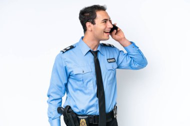 Young police caucasian man isolated on white background keeping a conversation with the mobile phone