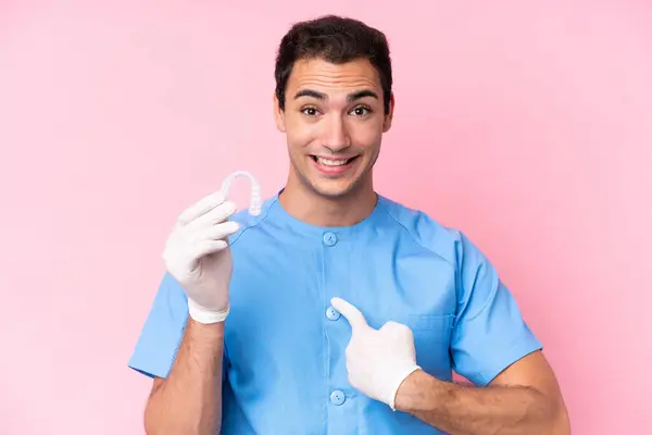 Hombre Caucásico Dentista Sosteniendo Frenos Invisibles Aislados Sobre Fondo Rosa — Foto de Stock