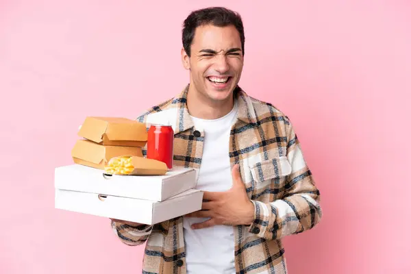 Young Caucasian Man Holding Fast Food Isolated Pink Background Smiling — Stock Photo, Image