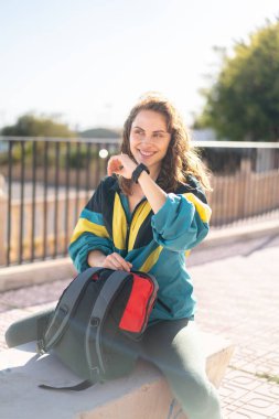 Kampüste sırt çantasıyla oturan genç bir kız öğrenci.