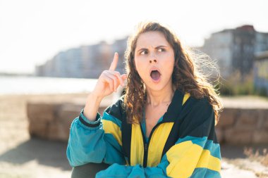 Açık havada gezen genç bir bayan bir fikir düşünüyor.