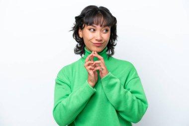 Genç Arjantinli kadın beyaz arka planda bir şeyler planlıyor.