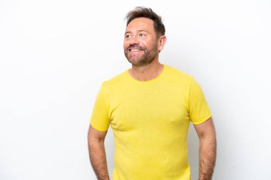 Beyaz arka planda izole edilmiş orta yaşlı beyaz bir adam yukarı bakarken bir fikir düşünüyor.