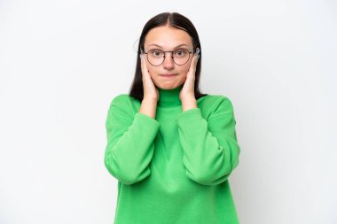 Beyaz arka planda izole edilmiş genç beyaz kadın hayal kırıklığına uğramış ve kulaklarını kapatmış.